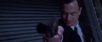 Movie still from “Snake Eyes” (1998), directed by Brian De Palma – A person holding a gun in a dark room; Close Up shot, Low angle