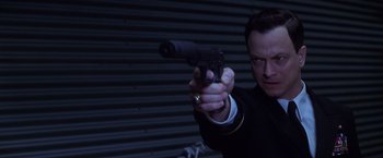 Movie still from “Snake Eyes” (1998), directed by Brian De Palma – A man holding a gun pointed at the camera; Close Up shot, Low angle