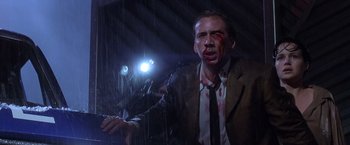 Movie still from “Snake Eyes” (1998), directed by Brian De Palma – A man with blood on his face is holding a cell phone in the rain; Close Up shot, Low angle
