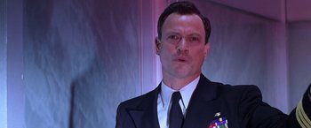 Movie still from “Snake Eyes” (1998), directed by Brian De Palma – A person wearing a suit and tie; Close Up shot, Low angle