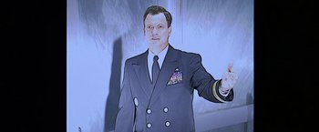 Movie still from “Snake Eyes” (1998), directed by Brian De Palma – A man in a suit and tie standing in front of a window; Close Up shot, Low angle