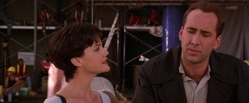 Movie still from “Snake Eyes” (1998), directed by Brian De Palma – A woman sitting in front of a man; Close Up shot, Over the shoulder angle