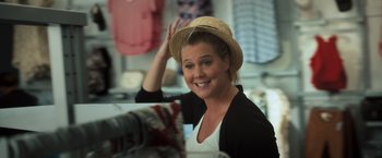 Movie still from “Snatched” (2017), directed by Jonathan Levine – A woman wearing a straw hat in front of a mirror; Medium shot, Over the shoulder angle