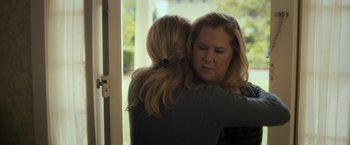 Movie still from “Snatched” (2017), directed by Jonathan Levine – Two women hugging each other in front of a window; Medium shot, Over the shoulder angle