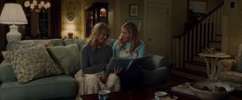Movie still from “Snatched” (2017), directed by Jonathan Levine – Two women sitting on a couch looking at a book; Medium shot, Over the shoulder angle