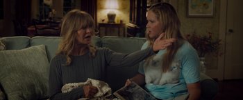 Movie still from “Snatched” (2017), directed by Jonathan Levine – Two women sitting on a couch one of which is holding a book; Medium shot, Over the shoulder angle
