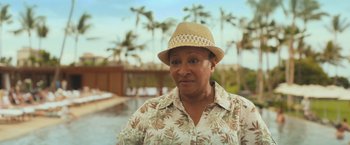 Movie still from “Snatched” (2017), directed by Jonathan Levine – An older woman wearing a straw hat near a swimming pool; Close Up shot, Over the shoulder angle