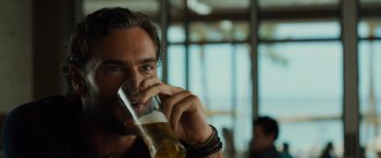 Movie still from “Snatched” (2017), directed by Jonathan Levine – A person holding a glass of beer; Close Up shot, Over the shoulder angle