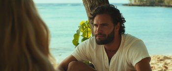 Movie still from “Snatched” (2017), directed by Jonathan Levine – A man sitting next to a tree on the beach; Close Up shot, Over the shoulder angle