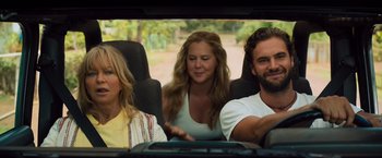 Movie still from “Snatched” (2017), directed by Jonathan Levine – A group of people sitting in the back of a car; Medium shot, Over the shoulder angle