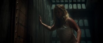 Movie still from “Snatched” (2017), directed by Jonathan Levine – A woman standing in a dark room next to a wall; Medium shot, High angle
