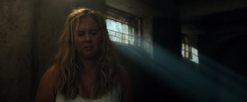 Movie still from “Snatched” (2017), directed by Jonathan Levine – A woman with blonde hair is standing in the sunlight; Medium shot, Low angle