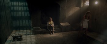 Movie still from “Snatched” (2017), directed by Jonathan Levine – A woman sitting on steps in front of a fire place; Wide shot, High angle