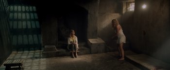 Movie still from “Snatched” (2017), directed by Jonathan Levine – A woman sitting on the ground next to another woman in front of a fire place; Wide shot, High angle