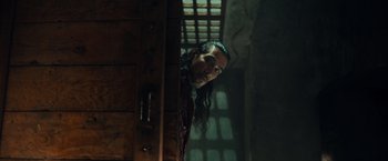 Movie still from “Snatched” (2017), directed by Jonathan Levine – A man with long black hair and a chain around his neck; Medium shot, Low angle