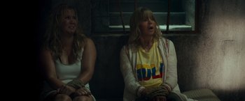 Movie still from “Snatched” (2017), directed by Jonathan Levine – Two women sitting next to each other with ropes around their ankles; Medium shot, High angle