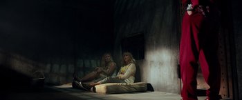 Movie still from “Snatched” (2017), directed by Jonathan Levine – Two women sitting on the ground in front of a wall; Wide shot, Low angle