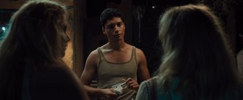 Movie still from “Snatched” (2017), directed by Jonathan Levine – A man in a tank top is holding something in his hand; Close Up shot, Over the shoulder angle