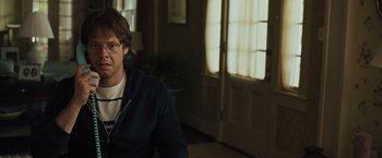Movie still from “Snatched” (2017), directed by Jonathan Levine – A man sitting in front of an open door in a room; Close Up shot, Over the shoulder angle