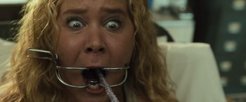 Movie still from “Snatched” (2017), directed by Jonathan Levine – A person holding a toothbrush in her mouth; Close Up shot, Overhead angle