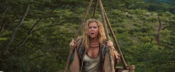 Movie still from “Snatched” (2017), directed by Jonathan Levine – A woman with blonde curly hair is holding on to a rope swing; Medium shot, Overhead angle