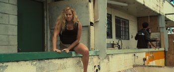 Movie still from “Snatched” (2017), directed by Jonathan Levine – A woman sitting on the ledge of an old building; Medium shot, Low angle