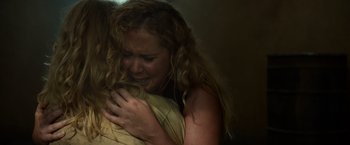 Movie still from “Snatched” (2017), directed by Jonathan Levine – A woman hugging another woman in a dark room; Close Up shot, Overhead angle