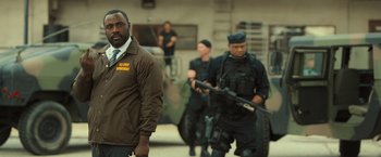 Movie still from “Snatched” (2017), directed by Jonathan Levine – A group of men standing next to each other holding guns; Medium shot, Over the shoulder angle