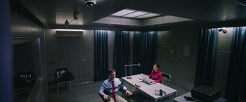Movie still from “Snowden” (2016), directed by Oliver Stone – A man and a woman sitting at a table in front of a computer; Wide shot, High angle