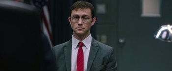 Movie still from “Snowden” (2016), directed by Oliver Stone – A man in a suit and red neck tie; Close Up shot, Over the shoulder angle