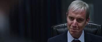 Movie still from “Snowden” (2016), directed by Oliver Stone – A person wearing a suit and tie; Close Up shot, Over the shoulder angle