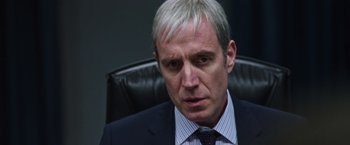 Movie still from “Snowden” (2016), directed by Oliver Stone – A person wearing a suit and tie; Close Up shot, Over the shoulder angle