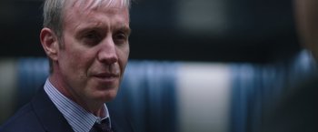 Movie still from “Snowden” (2016), directed by Oliver Stone – A person wearing a suit and tie; Close Up shot, Over the shoulder angle