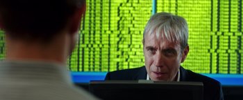 Movie still from “Snowden” (2016), directed by Oliver Stone – An older man looking at a computer screen; Close Up shot, Over the shoulder angle