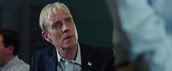 Movie still from “Snowden” (2016), directed by Oliver Stone – A person wearing a suit and tie; Close Up shot, Over the shoulder angle