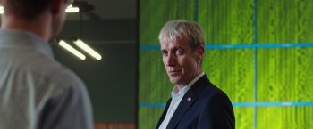 Movie still from “Snowden” (2016), directed by Oliver Stone – A man in a black suit and white shirt; Close Up shot, Low angle