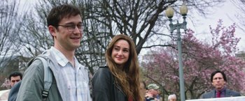 Movie still from “Snowden” (2016), directed by Oliver Stone – A young man and a young woman standing next to each other in front of a tree; Close Up shot, Over the shoulder angle