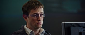 Movie still from “Snowden” (2016), directed by Oliver Stone – A person wearing glasses; Close Up shot, Over the shoulder angle