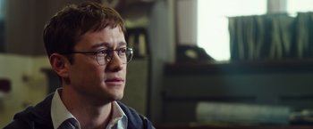 Movie still from “Snowden” (2016), directed by Oliver Stone – A man with glasses is looking into the distance; Close Up shot, Over the shoulder angle