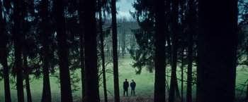 Movie still from “Snowden” (2016), directed by Oliver Stone – Two people standing in the middle of a forest; Extreme Wide shot, High angle