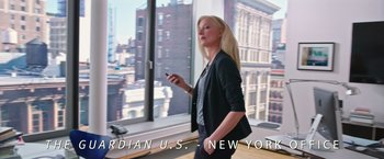 Movie still from “Snowden” (2016), directed by Oliver Stone – A woman standing in front of a window holding a cell phone; Medium shot, Low angle