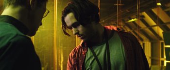 Movie still from “Snowden” (2016), directed by Oliver Stone – A young man in a green shirt and a red shirt; Close Up shot, Low angle