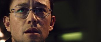 Movie still from “Snowden” (2016), directed by Oliver Stone – A person wearing glasses; Close Up shot, Low angle