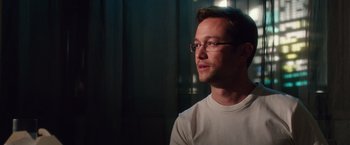 Movie still from “Snowden” (2016), directed by Oliver Stone – A man wearing glasses and a white t - shirt; Close Up shot, Over the shoulder angle