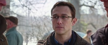 Movie still from “Snowden” (2016), directed by Oliver Stone – A person wearing glasses with trees in the background; Close Up shot, Over the shoulder angle