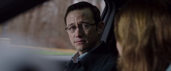 Movie still from “Snowden” (2016), directed by Oliver Stone – A man sitting in the back seat of a car; Close Up shot, Over the shoulder angle
