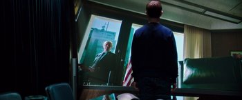Movie still from “Snowden” (2016), directed by Oliver Stone – A man standing in front of a mirror looking at himself in the mirror; Medium shot, Over the shoulder angle