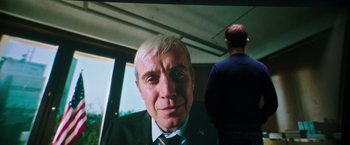 Movie still from “Snowden” (2016), directed by Oliver Stone – A man's face on a television screen; Medium shot, Over the shoulder angle