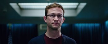 Movie still from “Snowden” (2016), directed by Oliver Stone – A person wearing glasses and a jacket; Close Up shot, Low angle