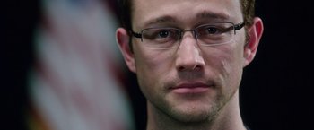 Movie still from “Snowden” (2016), directed by Oliver Stone – A person wearing glasses; Close Up shot, Over the shoulder angle